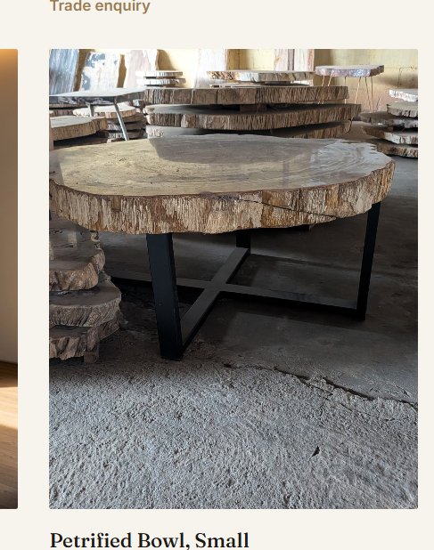 A round petrified wood table on a steel cross-base in the Java workshop.